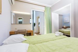 卡尔扎迈纳君主海滩酒店的一间卧室配有两张床、一张桌子和一面镜子