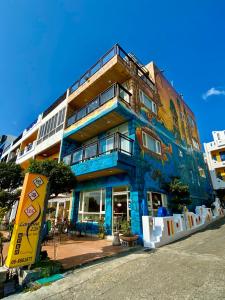 垦丁大街恋海126 海滩旅栈 的蓝色的建筑,旁边是一幅画