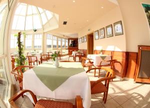 玛丽亚温泉夫罗拉酒店的一间带桌椅的用餐室和大窗户