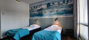 萨翁林纳Tanhuvaara Sport Resort的墙上画画的房间里设有两张床