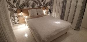 尼斯Les Grands Cedres的卧室内的一张带白色床单和枕头的床