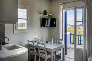 纳乌萨PURE WHITE 1BD house with amazing Sea Views in Naousa的厨房以及带桌椅的用餐室。