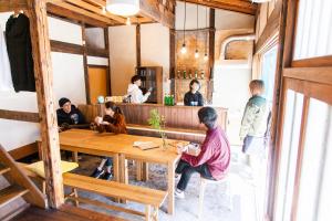 福冈Fukuoka Guesthouse SHIP的一群坐在餐厅桌子上的人