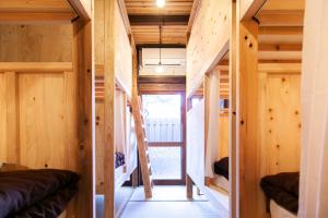 福冈Fukuoka Guesthouse SHIP的一座小房子,设有木墙和楼梯