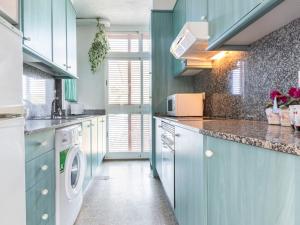 维拉福林Apartment Reus Mediterrani-1 by Interhome的厨房配有蓝色橱柜、洗衣机和烘干机