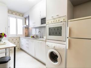 维拉福林艾迪埃斯基罗尔维拉公寓的厨房配有白色橱柜、洗衣机和烘干机