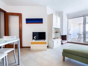 维拉福林艾迪埃斯基罗尔维拉公寓的白色的客厅配有电视和桌子
