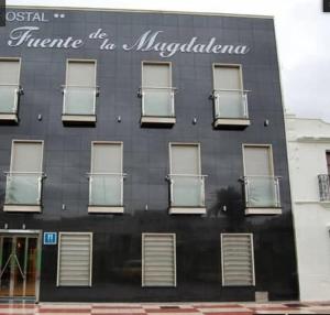 Santa Amalia马格达莱纳富恩特酒店的一座黑色的建筑,上面有窗户和标志