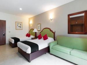 莱昂Capital O Hotel Vitale的酒店客房,设有两张床和一张沙发