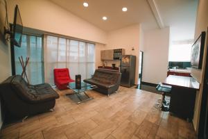 麦德林Provenza Lofts的客厅配有两张沙发和一张红色椅子