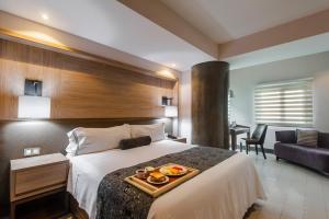 瓜达拉哈拉雷亚尔马斯特莱扎酒店的一间酒店客房,配有一张床铺,上面放着一个食物托盘