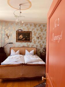 普劳恩阿尔特斯普劳恩旅馆的卧室配有一张床,墙上挂有绘画作品