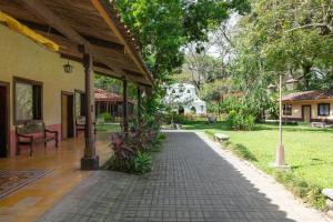 雅科Villa Lapas Jungle Village的通往带房子的院子的走道