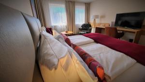 林道迈克斯酒店的配有枕头的床的酒店客房