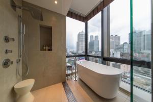 东京新宿花JR九州酒店的带浴缸的浴室和大窗户