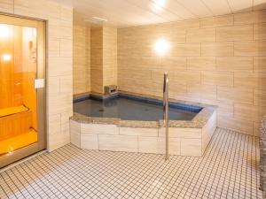 大垣Kuretake Inn Ogaki Ekimae的浴室设有按摩浴缸,铺有瓷砖地板。