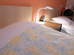 府中市府中旭格兰杜尔经济型酒店的床上有鲜花的毯子