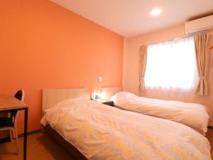 府中市府中旭格兰杜尔经济型酒店的一间卧室设有两张床和窗户。