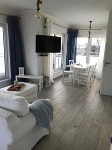 FehmarnsundStrandhaus Appartement - Seeschwalbe OG的客厅配有沙发和桌子