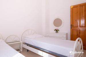 布里亚蒂科Residence Albatros的一间白色卧室,配有两张床和镜子
