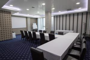蒂米什瓦拉冰雪SPA度假酒店的一间会议室,配有桌椅和白板
