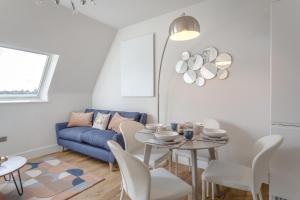 希钦Stylish & Modern: Central Hitchin - with Parking的客厅配有桌子和蓝色沙发