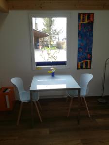 迈林根Montanara的窗户间里的一张桌子和两把椅子