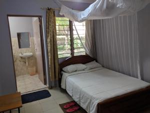 LibweziKambua Resort的一间卧室配有一张床,浴室设有窗户