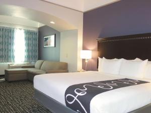 杜马杜马拉昆塔套房酒店的酒店客房设有一张大床和一张沙发。