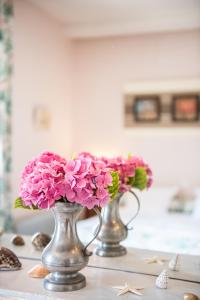 尚托奈珀塞庄园酒店的两个花瓶,上面放着粉红色的花朵