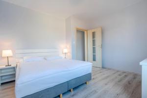 弗瓦迪斯瓦沃沃赫乐罗沃公寓的白色卧室配有一张大床和两盏灯。