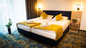 韦巴Plaża Resort的酒店客房,配有一张带黄色床单的大床