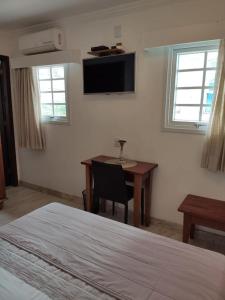 萨尔瓦多Pousada Bahia Pelô的卧室配有书桌和墙上的电视。