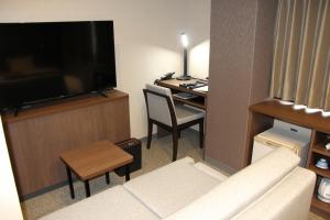 松江市松江城市酒店的带沙发、电视和书桌的客厅