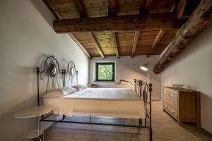 圣费利切德尔贝纳科Agriturismo Le Chiusure的一间卧室设有一张大床和木制天花板