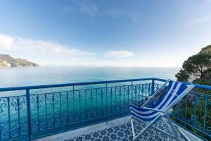 拉维罗圣迈克尔别墅酒店的蓝色椅子,位于俯瞰大海的阳台