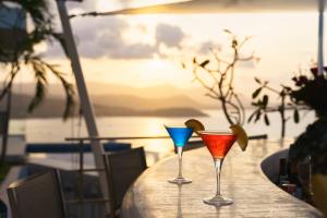 班拉克海滩UniQue BoutiQue Resort的餐桌上三杯鸡尾酒,享有海景
