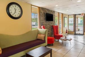 特拉华峡谷Pocono Inn & Banquet - Stroudsburg的一间配有沙发和墙上时钟的等候室