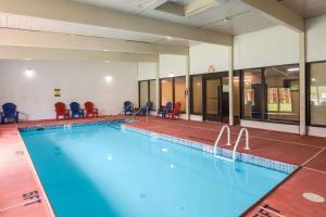 特拉华峡谷Pocono Inn & Banquet - Stroudsburg的大楼内一个带红色椅子的大型游泳池