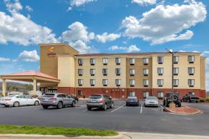 佩勒姆Comfort Suites Pelham Hoover I-65的停车场内有车辆的旅馆