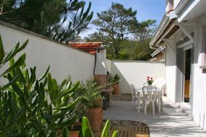 乌尔坦Villa with pool & nice terraces close to the beach的庭院拥有白色的墙壁,配有桌椅。