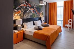 敖德萨斯科佩里设计酒店的一间卧室配有一张带橙色毯子的大床