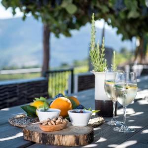 杜罗河畔瓦伦萨Quinta da Côrte的一张桌子,上面放着一杯葡萄酒和一盘水果