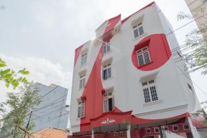 雅加达OYO 1111 Pasar Baru Inn的白色和红色的建筑,有红色的修剪