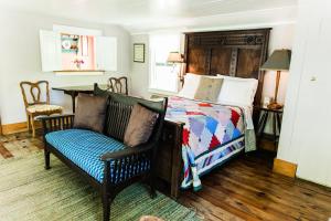 曼蒂奥Roanoke Island Inn的一间卧室配有一张床、一张沙发和一把椅子