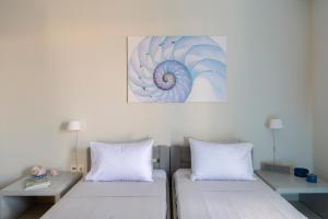 皮索利瓦迪SPLASH with amazing Sea Views in Piso Livadi的墙上画画的房间里设有两张床