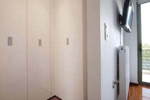 雅典Voula, A modern, minimal and stylish, apartment的一间设有白色橱柜和窗户的客房