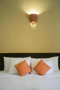 格拉纳达领事之家酒店的一张带橙色和白色枕头及轻便的床铺