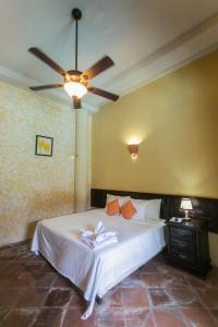 格拉纳达领事之家酒店的一间卧室配有一张带吊扇的床