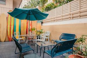 檀香山波里尼西亚海滩俱乐部旅馆的庭院配有桌椅和遮阳伞。